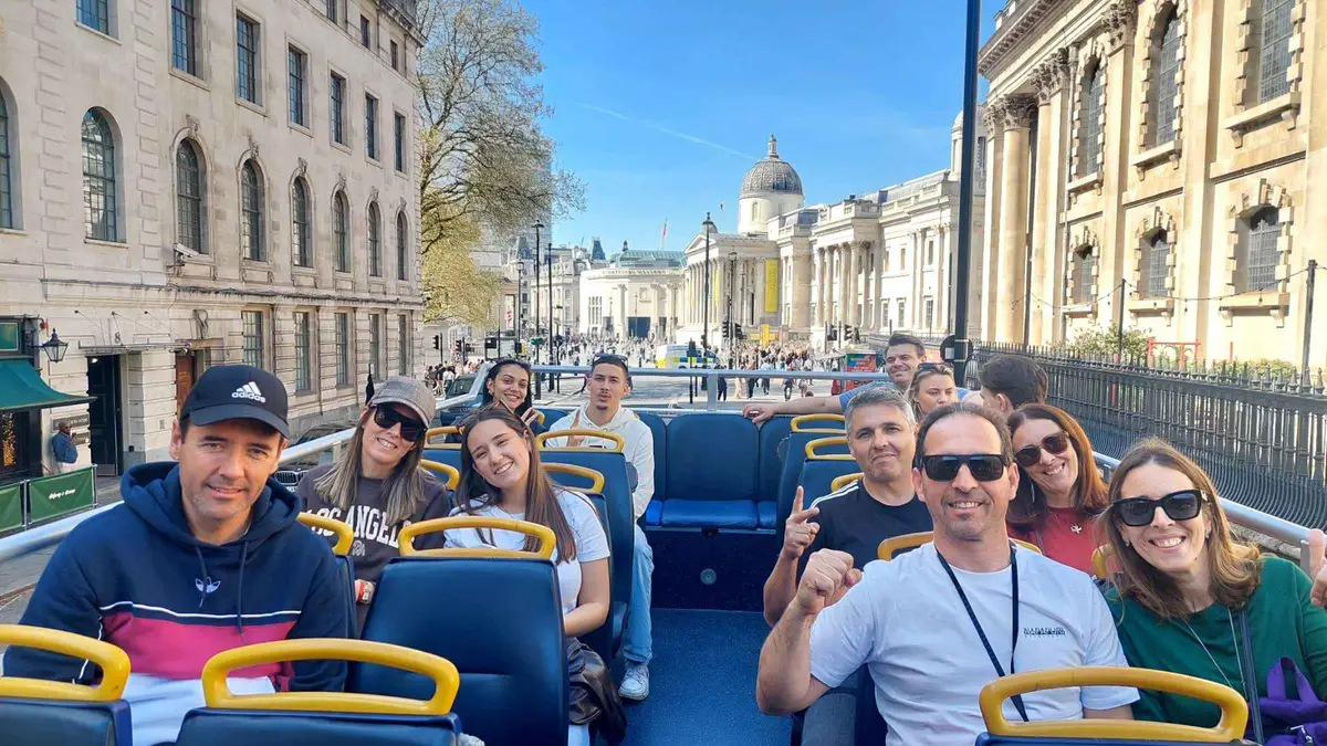 Red open-top bus passing Big Ben on a panoramic London 2 day itinerary tour